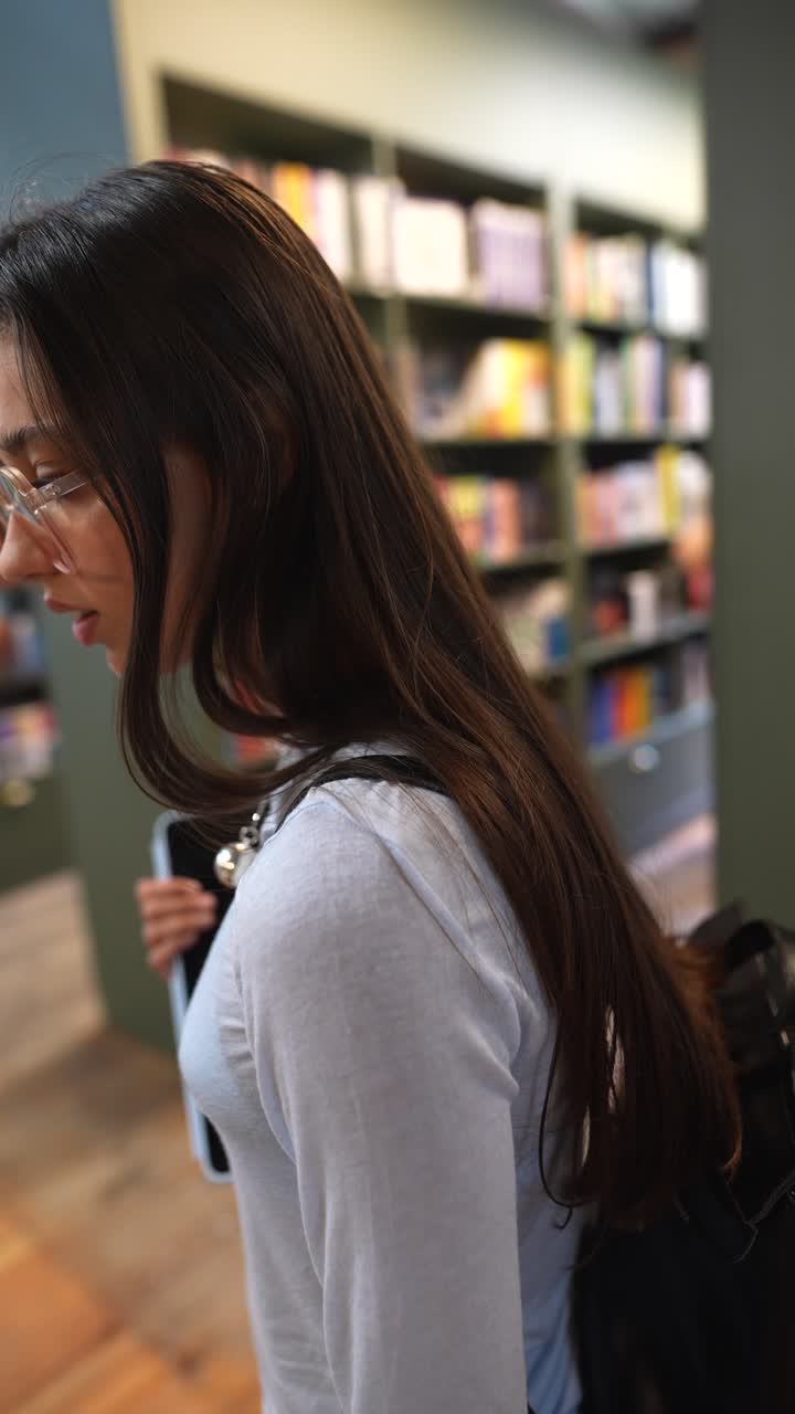 Teenage girl in a library with a tablet