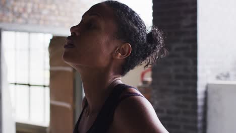 african american woman resting after exercise standing in empty urban building