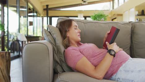 Mujer-Embarazada-Caucásica-Relajada-Tumbada-En-El-Sofá-Y-Leyendo-Un-Libro