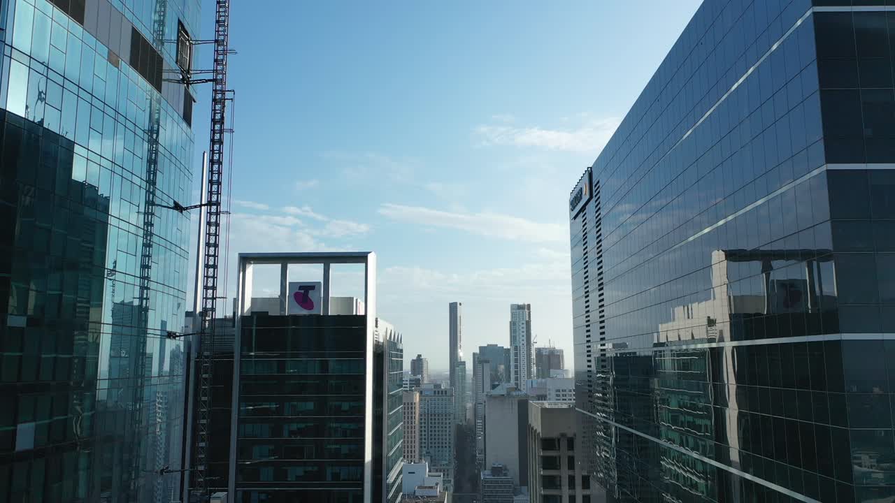 하강 외부 리프트로 건설중인 브리즈번 마천루의 공중 패닝 다운 샷