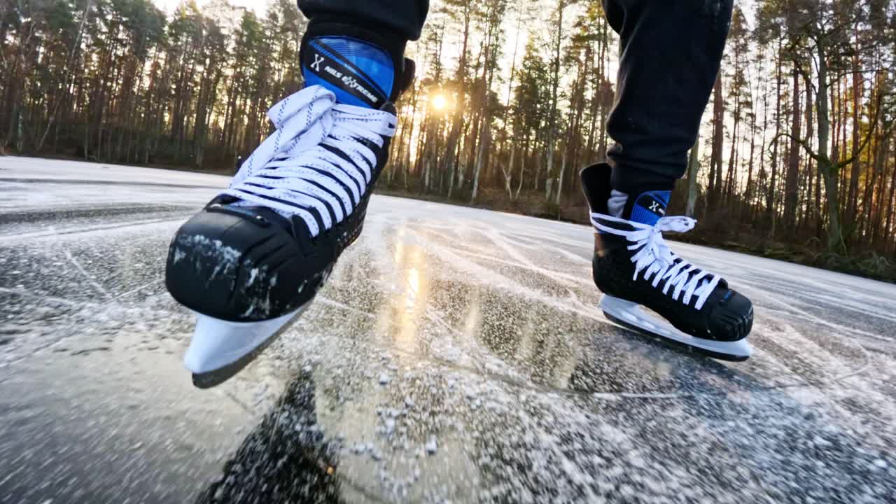 Slow motion skating, frozen lake, forest background creating calm winter mood