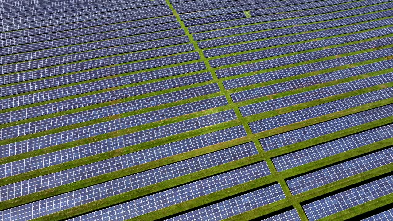 Photovoltaic solar farm generating clean and eco-friendly energy, aerial view, bright sunlight, drone flight