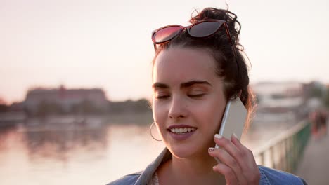 una mujer joven hablando por teléfono móvil.