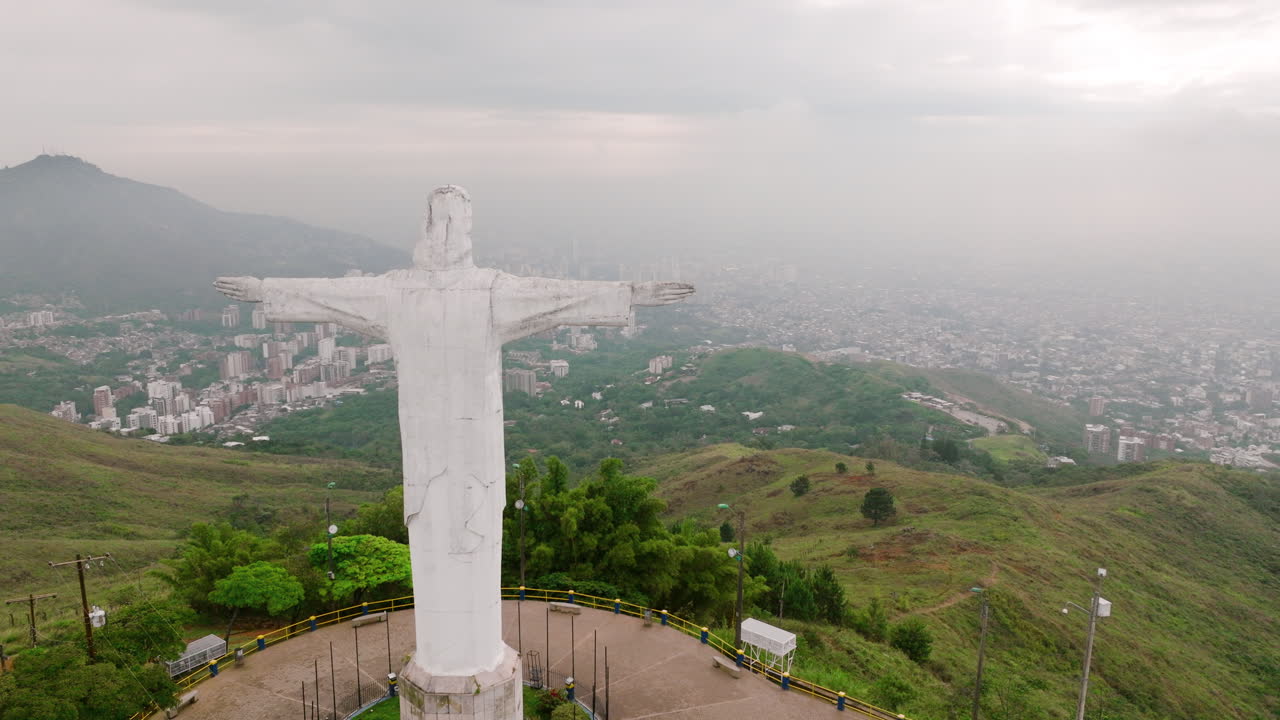 imágenes aéreas que pasan por el lado derecho de la estatua de cristo rey jesús en la cima de una montaña en las afueras de cali, colombia
