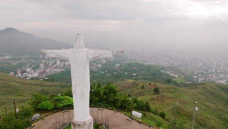 aerial footage flying past the right side of the cristo rey jesus statue on top of a mountain outside of cali, colombia