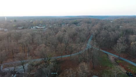 Aerial-View-Of-Asphalt-Backroad-Through-Trees-During-Fall-Season-In-Rural-Oklahoma-In-Middle-Of-Nowhere-USA