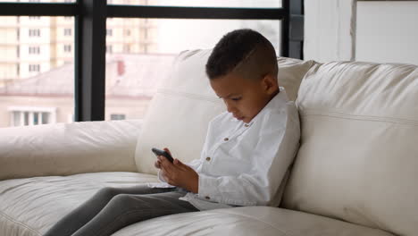 boy using smartphone on a couch