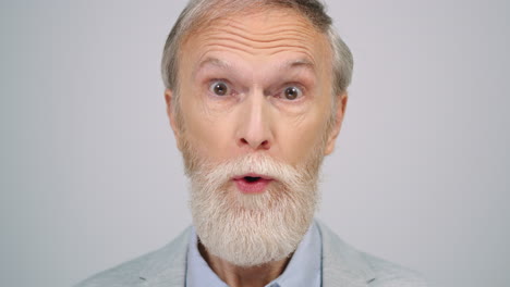 Smiling-old-man-looking-camera-indoors.-Surprised-gentleman-posing-in-studio.