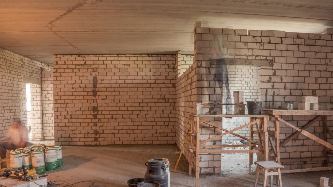 Muratori che posano pareti in mattoni all'interno di un appartamento con attrezzi professionali in timelapse. Operai al lavoro, muratori che costruiscono un muro, appaltatore e operaio. Materiali da costruzione intorno.