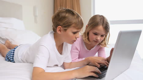 siblings using a laptop