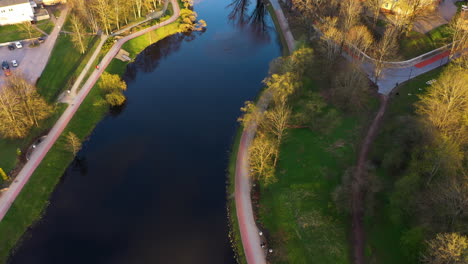 Vista-Aérea-Del-Parque-Con-Lago-Y-Senderos-Al-Atardecer