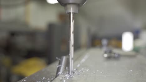 closeup of a drill bit drilling aluminium in a industrial manufacturing workshop