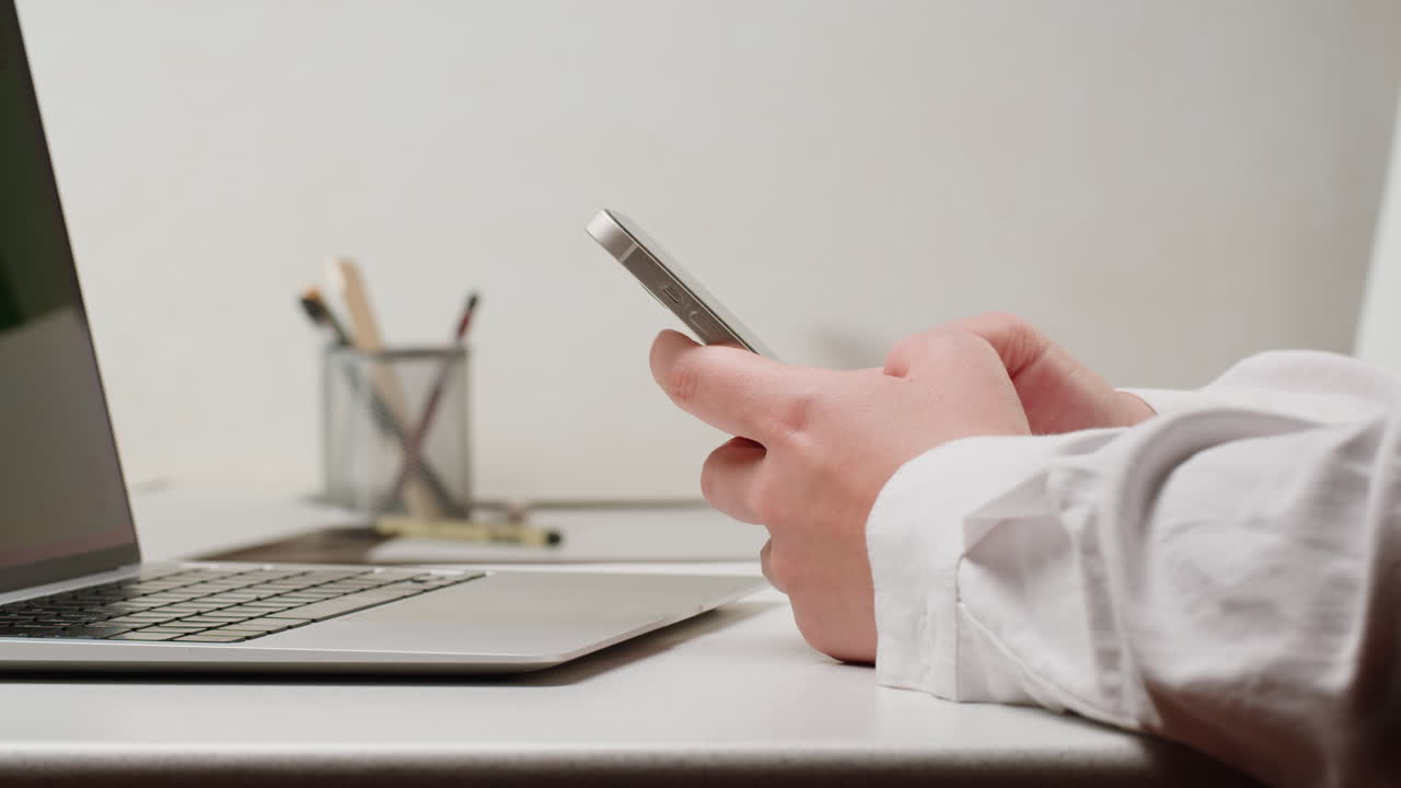 persona que utiliza un teléfono inteligente en un escritorio