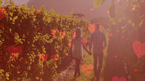 animación de corazones digitales sobre una pareja caucásica caminando por una plantación