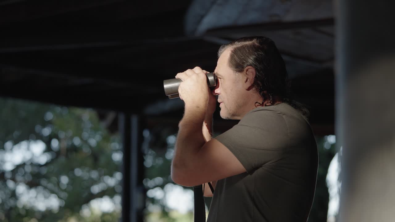 hombre mirando a través de binoculares en unas vacaciones de safari en áfrica