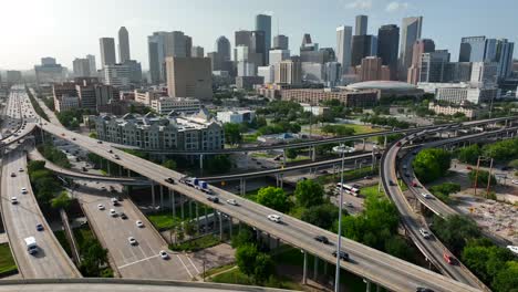 Aerial-pullback-reveal-of-downtown-Houston-Texas-skyline-and-interstate-traffic-on-freeway-highways