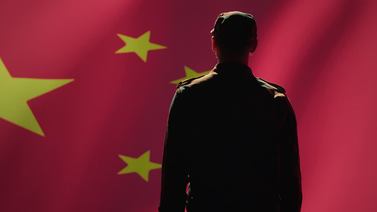 soldado haciendo saludo con el gesto de la mano hacia la bandera china