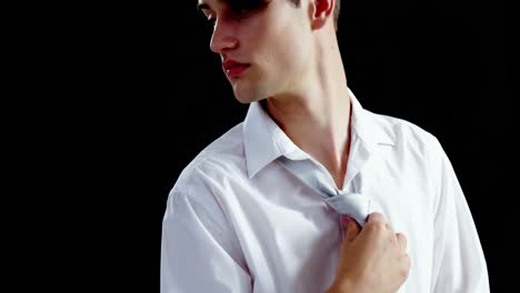 androgynous man adjusting his tie