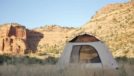 white tent with black rocks canyon in background, static shot with copy space