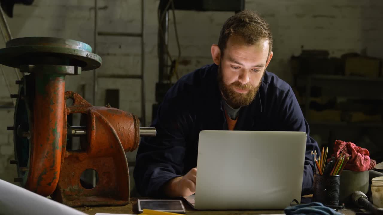 Fabbro che usa il laptop in officina 4k
