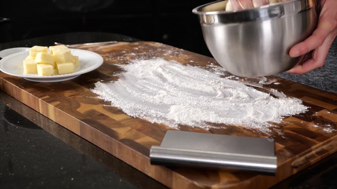 Kneading bread dough into a dough ball on a floured wood cutting board