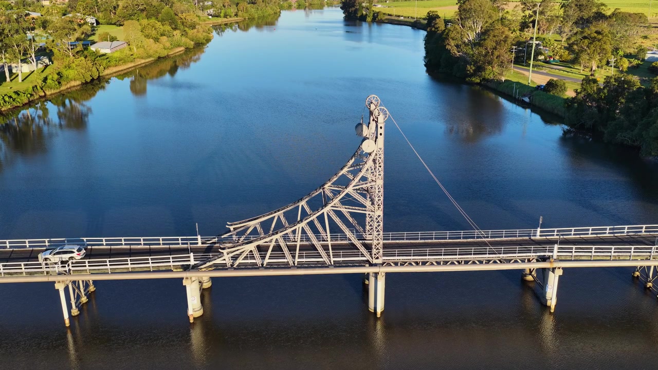 Ilmakuva dronella pystysuoraan nousevasta ristikkosillasta tyynen veden yllä Macleanissa, Australiassa.