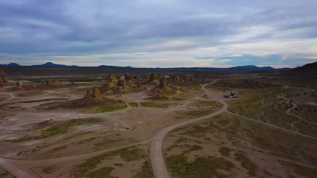 воздушные кадры беспилотного самолета, летящего в сторону trona pinnacles, кемперы видны на заднем плане