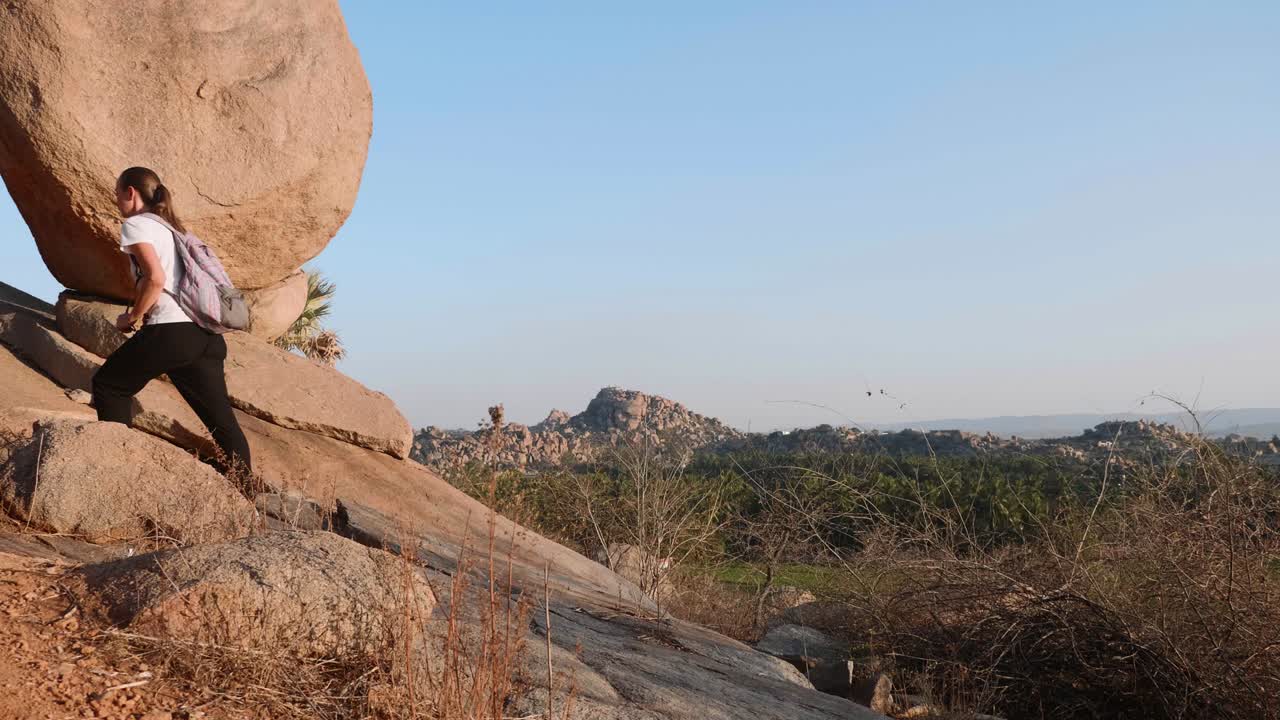 joven turista con mochila caminando por el sendero en las montañas