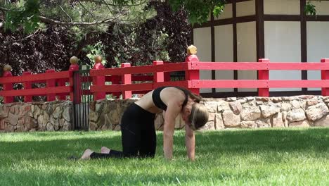 a young woman works out in a park as she flexes her muscular core. yoga as a part of her health and wellbeing