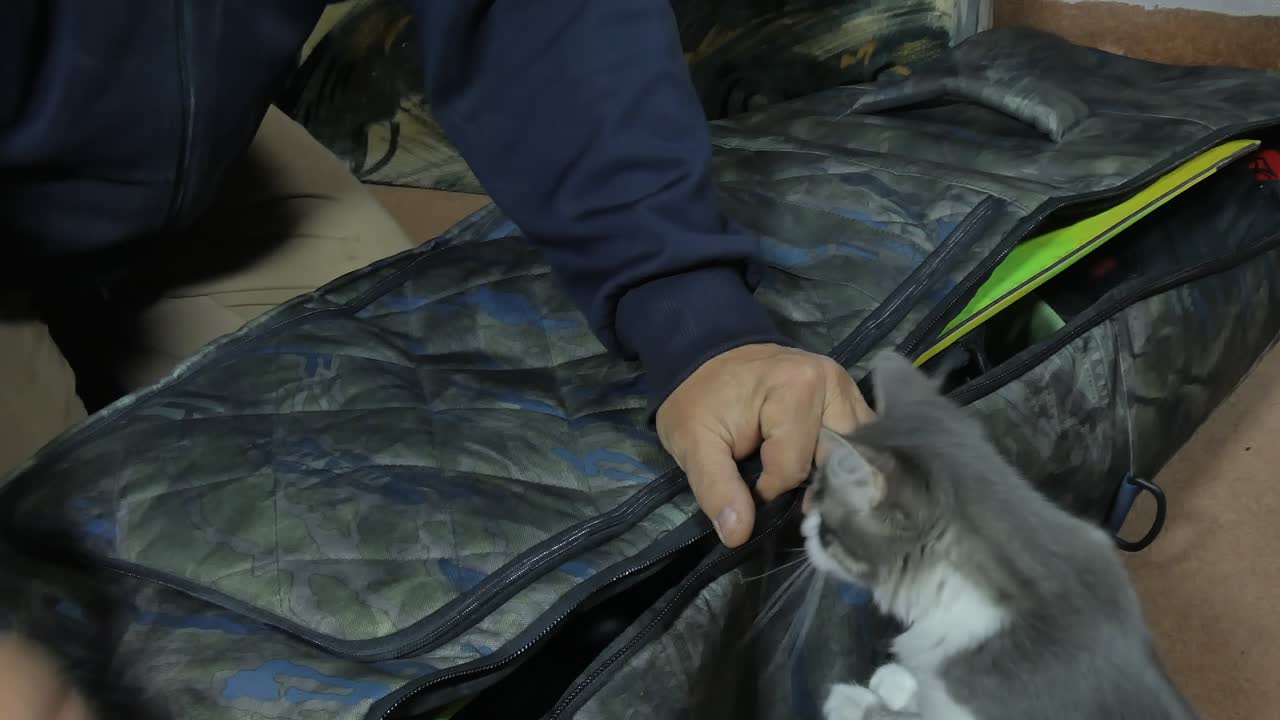 한 남자가 큰 스노우보드 가방의 지퍼를 닫습니다. 클로즈업