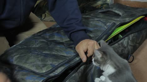 a man closes the zipper of a large snowboard bag. close-up