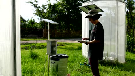 agronomist farmer using tablet to monitor plant in greenhouse. soil & water management in agriculture using mobile apps technology