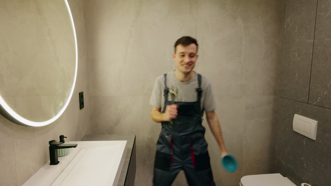 un fontanero gracioso cantando y bailando en un baño moderno.