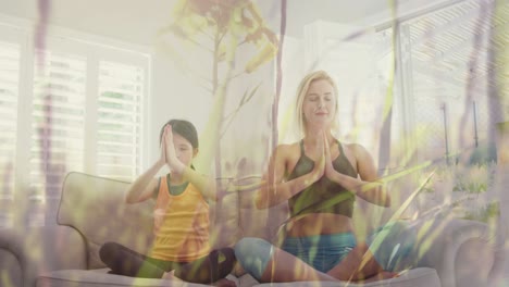 animación de hierba moviéndose sobre feliz mujer caucásica con su hija haciendo yoga