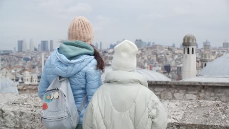 tourist people looking buildings and roofs landscape in ancient istanbul city,turkish, back view. female tourists admiring turkish city landscape