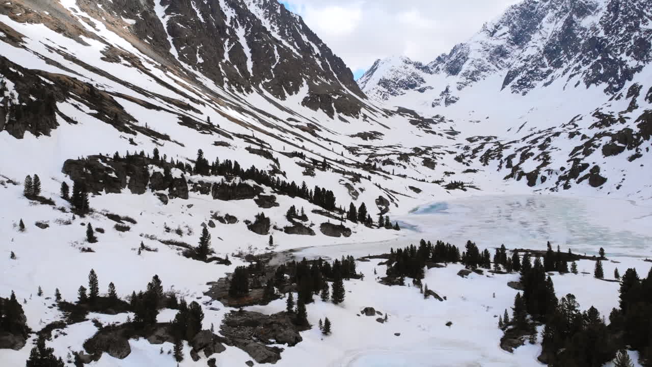 Snowy Mountain Landscape with Frozen Lakes and Pine Trees