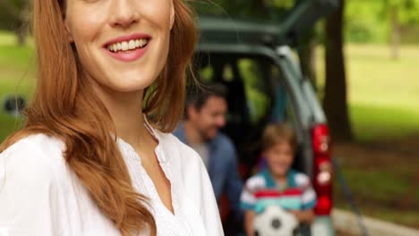 mother and daughter smiling at camera in front of father and son