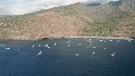 Tropical-bay-filled-with-white-traditional-fishing-boats,-Bali,-aerial