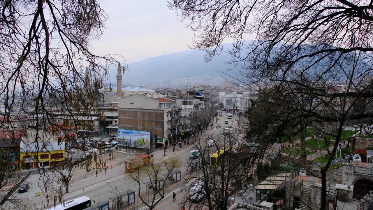 tráfico en el centro de bursa con automóviles y transporte público autobús amarillo con fondo de montaña ulu (uludag)