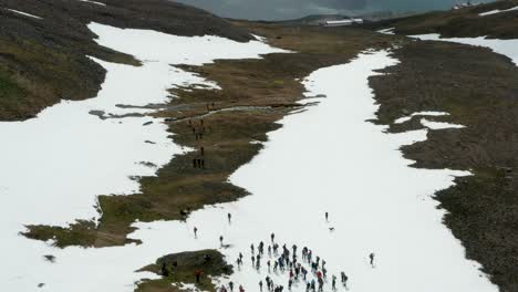 aerial of hiking expedition high in mountains with snow, iceland