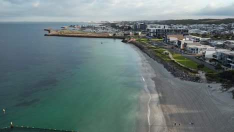 Cinematic-drone-shot-of-Coogee-Beach-with-luxury-buildings-in-Perth-City,-Western-Australia---backwards-flight