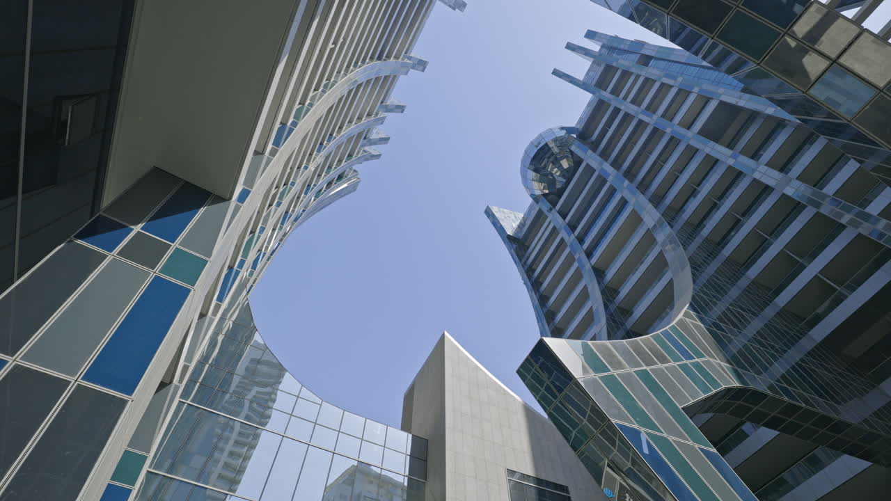 Modern Skyscrapers with Glass Facades Looking Up to Blue Sky