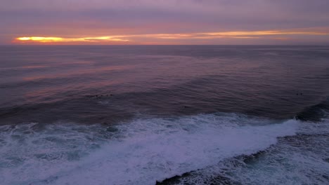 stunning sunset over ocean waves with surfers