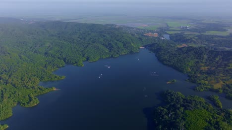 aerial wide shot of idyllic landscape with reservoir. rincon dam in dominicen republic. boat with foggy sky.