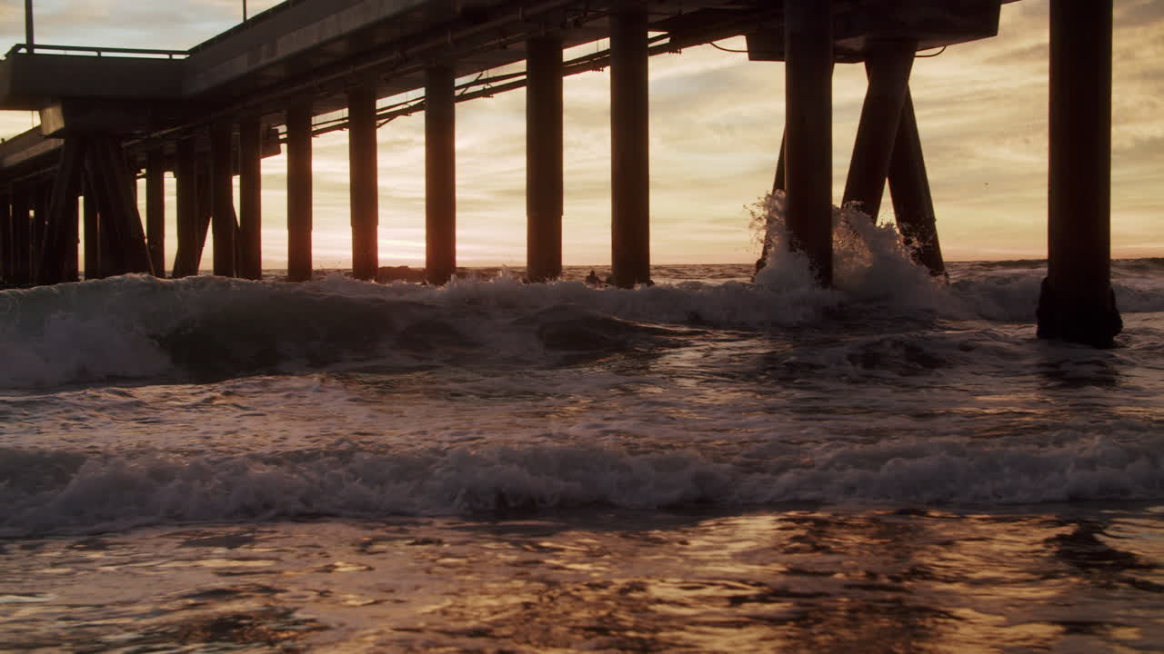 Sunset Waves Crashing Against a Pier