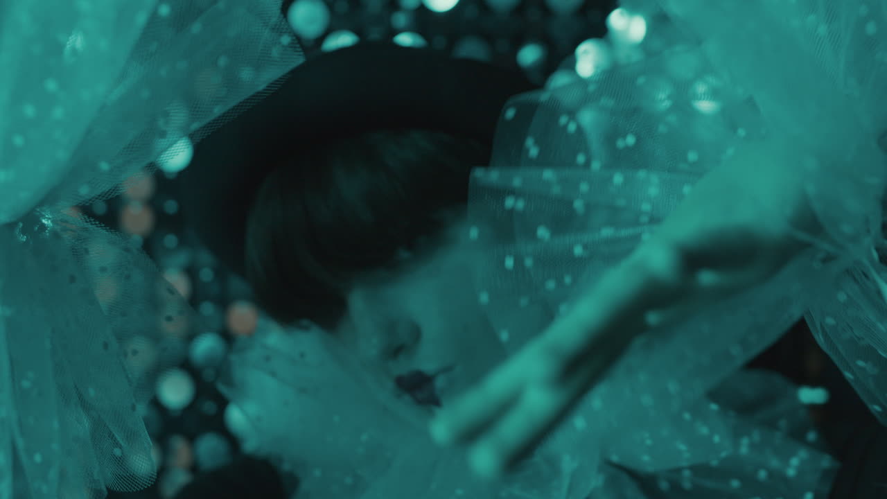 Close-up view of young woman leaning on a bright wall