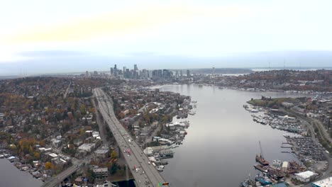 wide establishing drone shot of lake union passing underneath the i-5 bridge in seattle