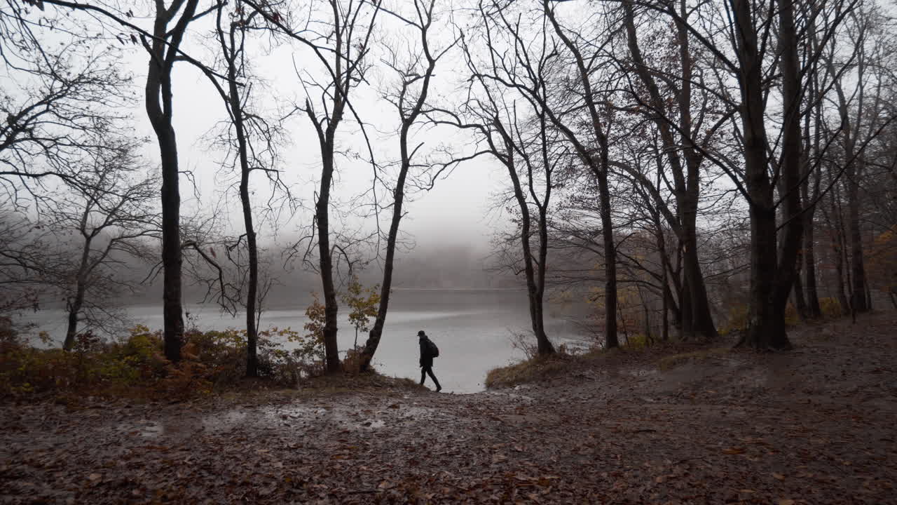 Guy walking through beautiful autumn beech forest under the rain in the Catalan mountains-1