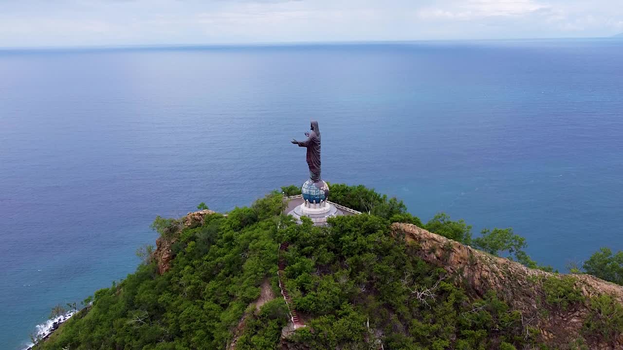 Aerial view rising of Cristo Rei statue landmark overlooking ocean in capital city Dili, Timor-Leste, Southeast Asia