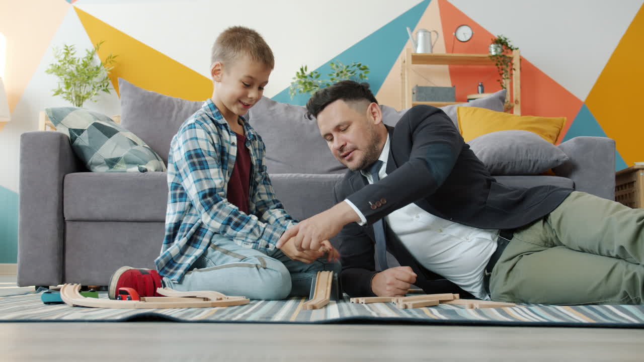 Father and son playing with train tracks